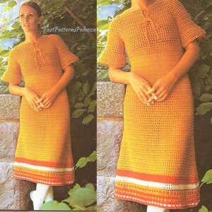 May include: A crochet dress in a bright orange color with a white and red trim. The dress has a round neckline and short sleeves. The dress is made with a simple crochet stitch and has a loose fit.