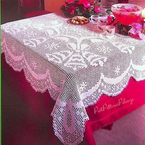 May include: White crocheted tablecloth with a delicate floral pattern. The tablecloth is laid on a red table and has a scalloped edge.