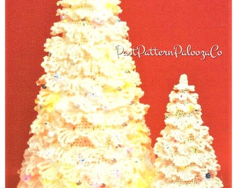 May include: Two crocheted Christmas trees, one large and one small, are decorated with white and colorful beads. The trees are on a red background.