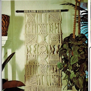 Könnte beinhalten: Ein Wandbehang aus Makramee mit einem geometrischen Muster in Creme. Der Behang ist mit "Autumn Mixture" und "Anleitung auf Seite 11" beschriftet.