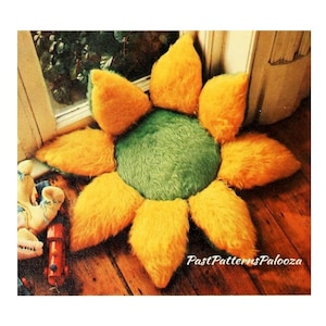 May include: A yellow and green plush sunflower floor cushion. The cushion has a round centre and eight petals.