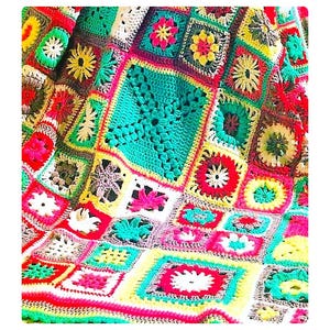 May include: A colourful crocheted blanket featuring a range of floral patterns in shades of red, yellow, green, and white.