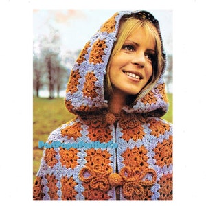 May include: A crochet hooded cape with a brown and blue geometric pattern. The cape has a button closure and a tassel detail.