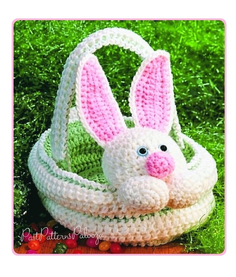 May include: A crochet basket featuring a white bunny head with pink inner ears and a pink nose, attached to the front. The basket has a white handle and a light green interior. The text PastPatternsPalooza is visible in the lower left corner.
