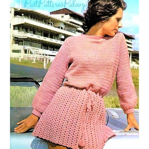 May include: A vintage image of a woman wearing a light pink crochet outfit. The outfit includes a long-sleeved sweater and a matching skirt with a drawstring waist. The text "Past Patterns Palooza" is visible in the upper left corner. The background features a building and a car.