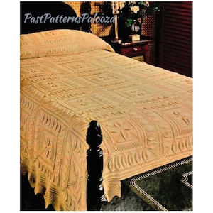 May include: A crocheted bedspread in a cream color with a floral pattern. The bedspread is on a bed with a dark wood headboard.