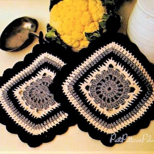 May include: Two crocheted pot holders in black, white, and gray with a scalloped edge. The pot holders feature a square design with a smaller square in the center.