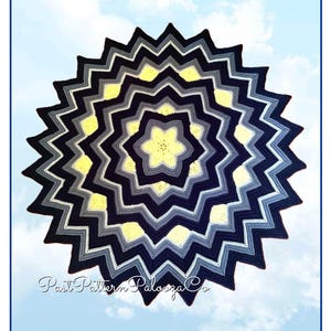 May include: A handmade, star-shaped crochet blanket in shades of navy, gray, white, and yellow. The blanket features a zig-zag pattern radiating from the center. The text "Past Pattern Palooza Co" is visible in the lower left corner.