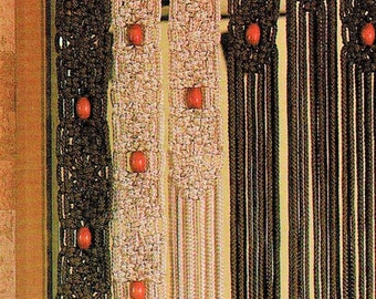 May include: A macrame curtain with three panels, each with a different pattern. The panels are made of brown, white, and beige cords and have red wooden beads woven into the design.