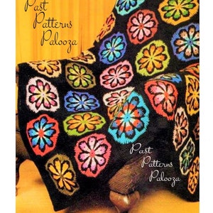 Può includere: Una coperta di uncinetto nera con motivi di fiori colorati. La coperta è drappeggiata su una poltrona marrone. Il testo "Past Patterns Palooza" è visibile negli angoli in alto a sinistra e in basso a destra dell'immagine.