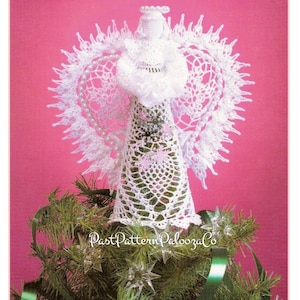 May include: A white crocheted angel Christmas tree topper with a halo and wings. The angel is adorned with a pearl necklace and stands atop a green Christmas tree. The image has the text "Past Pattern Palooza Co."