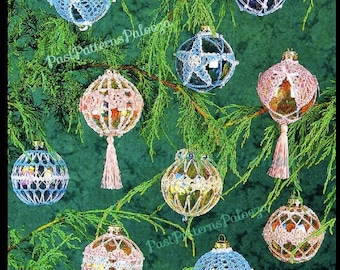 May include: Nine crocheted Christmas ornaments in various colors, including blue, pink, and white, hanging on a green evergreen tree branch. The ornaments are decorated with beads and tassels.