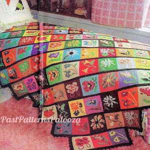 Può includere: Una coperta all'uncinetto colorata con un motivo floreale. La coperta è composta da quadrati con fiori e foglie di diversi colori. La coperta è su un letto con un copriletto a motivi floreali rosa e bianco.