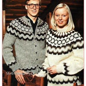 May include: A man and woman are wearing matching knitted sweaters. The sweaters are gray and cream-colored with a brown and white geometric pattern across the chest and sleeves. The man's sweater is a button-up cardigan. The woman's sweater is a crew neck.