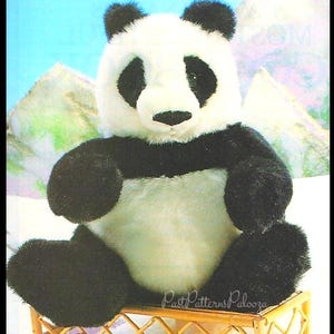 May include: A plush panda bear with black and white fur, sitting on a small, decorative wooden cart with red wheels. The panda has black eyes and ears. The cart has a diamond pattern.