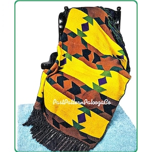 May include: A woven throw blanket featuring a geometric pattern in yellow, brown, black, green, and purple. The blanket has black fringe along the bottom edge and displays the text PastPatternPaloozaCo in white script across the center.