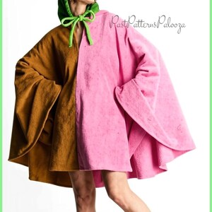 K&ouml;nnte beinhalten: Ein farblich abgesetzter Kapuzenumhang mit einer braunen rechten Seite und einer rosa linken Seite. Das Kleidungsst&uuml;ck verf&uuml;gt &uuml;ber eine leuchtend gr&uuml;ne Kapuze mit passenden gr&uuml;nen Bindeb&auml;ndern am Hals. Der Text PastPatternsPalooza ist oben rechts.
