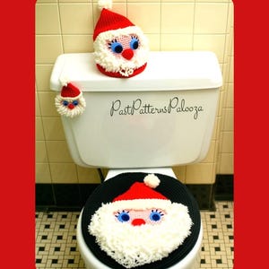 Könnte beinhalten: Ein gehäkeltes Weihnachtsmann-Set bestehend aus Toilettensitzbezug, Spülkastenabdeckung und einem kleinen Zubehörteil. Jedes Teil hat eine rote Mütze, einen weißen Bart, blaue Augen und eine rote Nase. Der Text PastPatternsPalooza ist auf dem Spülkasten zu sehen.