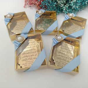 Pu&ograve; includere: Scatole dorate con nastro blu e decorazioni di perle. Ogni scatola contiene una placca dorata con calligrafia araba e il testo "Welcome Baby Shah 09.13.20".