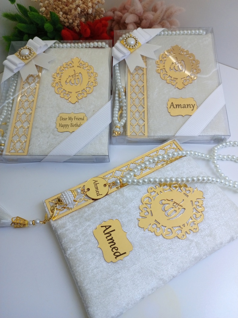 May include: Gift sets featuring a gold-colored decorative element with Arabic calligraphy, a white pearl beaded strand, and a matching bookmark. The sets are packaged in clear boxes with white ribbons and include personalized name tags. The text "Dear My Friend Happy Birthday" is visible.