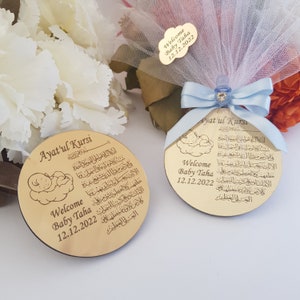 May include: Two gold-colored wooden plaques with a baby sleeping on a cloud design. The plaques feature the Arabic text "Ayat'ul Kursi" and the words "Welcome Baby Taha 12.12.2022".