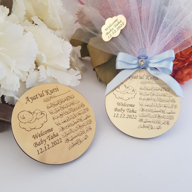 May include: Two gold-colored wooden plaques with a baby sleeping on a cloud design. The plaques feature the Arabic text "Ayat'ul Kursi" and the words "Welcome Baby Taha 12.12.2022".