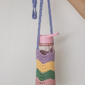 A crocheted water bottle holder with a purple, yellow, green, and pink striped pattern. The holder has a long purple strap.