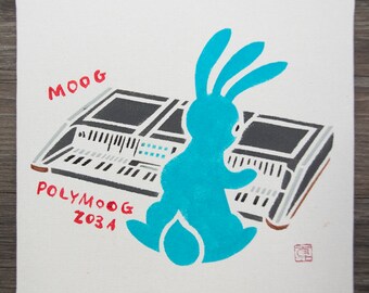 May include: Square canvas art featuring a stylized blue bunny playing a synthesizer. The synthesizer is gray and black with white keys. The words "MOOG" and "POLYMOOG 203A" are in red. A red stamp is in the lower right corner.