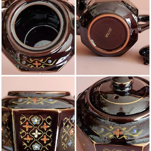 May include: A dark brown, octagonal tea set with gold trim and floral designs in red, blue, and white. The set includes a teapot and lid, showcasing a vintage aesthetic. The bottom of the teapot is marked "JAPAN".