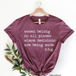 May include: A maroon t-shirt with the text "women belong in all places where decisions are being made -r.b.g." printed in white.