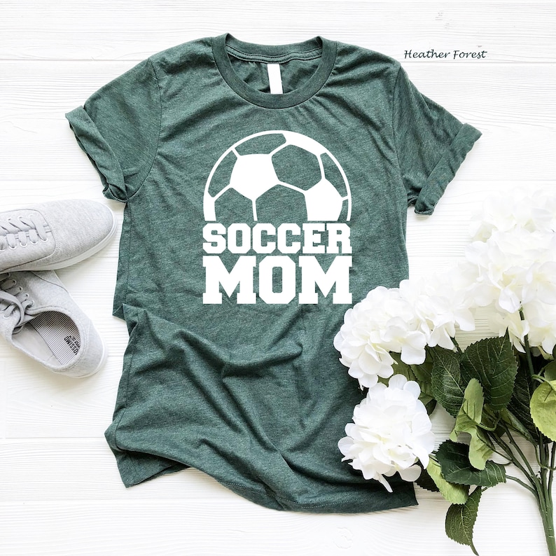 May include: A green t-shirt with a white soccer ball and the text "Soccer Mom" printed on it.