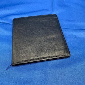 Una fina cartera plegable de piel de becerro en color negro.