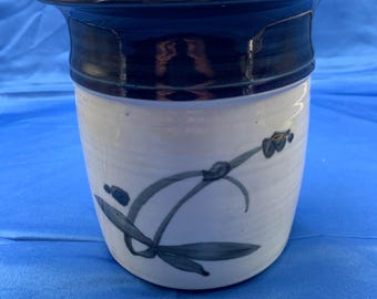 A crock with Asian like artwork and it’s signed.