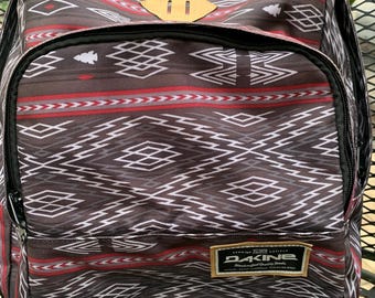 Dakine backpack in gray, red and white geometric design.