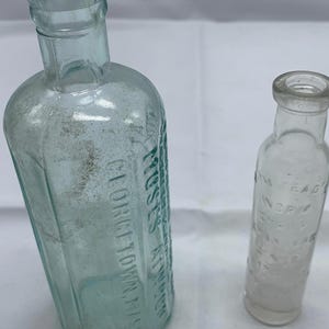 Both clear and blue vintage bottles once filled with medicinal cures!