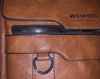 A “Man Bag”, brown cross body with strap and handle.