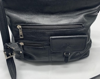 May include: Black leather crossbody bag with multiple zipped compartments and a front flap pocket. The bag features a long, adjustable shoulder strap and silver-tone hardware. The leather has a textured grain.