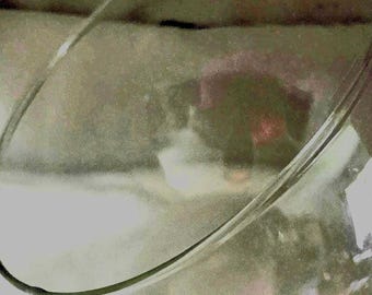 May include: A clear glass bowl with a curved rim. The bowl is empty and appears to be made of thick glass.