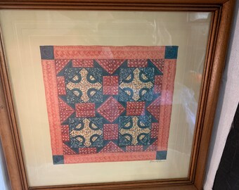 May include: Framed print of a quilt pattern with a red, blue, and yellow color scheme. The quilt pattern is a geometric design with a central cross shape. The print is signed "Dowden".