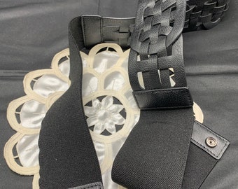 A faux leather, wide stretch belt that snaps closed in black.