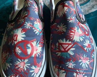 Un par de zapatillas Vans unisex sin cordones con estampado floral/graffiti.