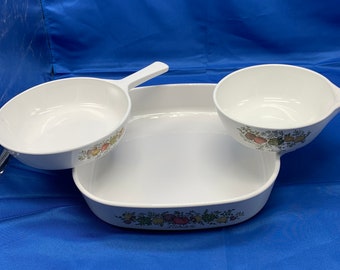 A trio of CorningWare, two small to medium cooktop and one large Cassarole dish.