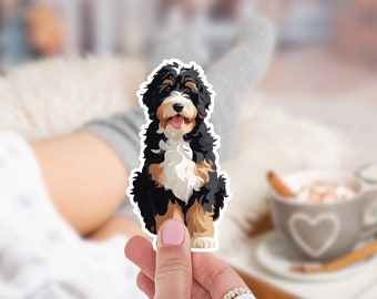 Könnte beinhalten: Ein schwarzer, weißer und brauner Doodle-Hundesticker. Der Hund sitzt mit herausgestreckter Zunge.