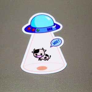 May include: A cartoon cow with black and white spots is being beamed up by a blue and white UFO. The cow is saying "Moo?" in a speech bubble.