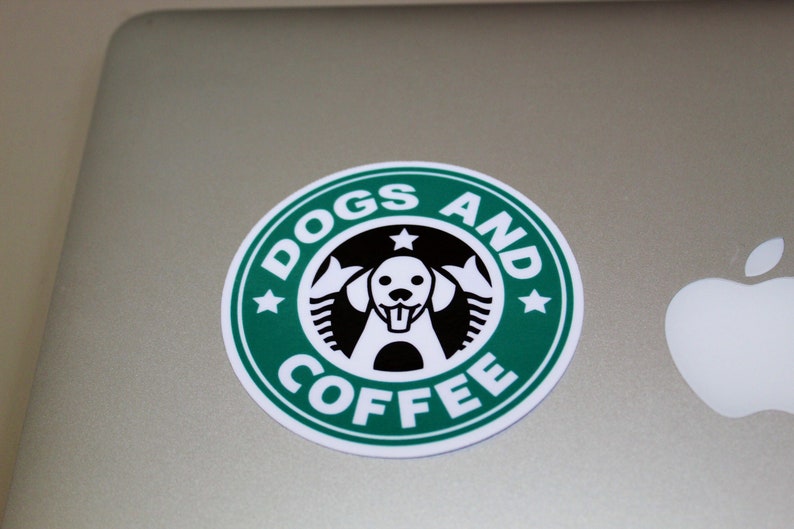 Puede incluir: Una pegatina verde y blanca con el texto "Dogs and Coffee" y una silueta en blanco y negro de la cabeza de un perro.