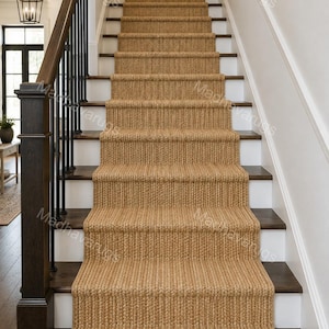 May include: A tan woven stair runner with a thick, braided texture covering the center of a staircase. The runner features a consistent, repeating rope-like pattern that extends from the bottom step up to the top landing of the wooden staircase.