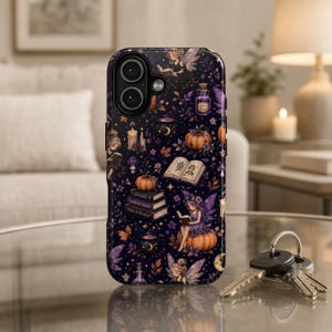 May include: A phone case with a dark purple background featuring illustrations of fairies, pumpkins, books, and potion bottles. The design includes stars, moons, and the text "Fairy Dust". The case has a glossy finish and a dual-camera cutout.
