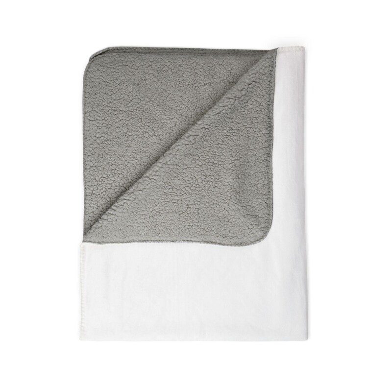 May include: A folded blanket with a white exterior and a gray, textured interior. The blanket is made of a soft material and is designed for comfort and warmth. The blanket is folded to display the contrasting colors and textures.