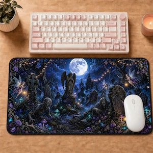 May include: A computer mouse pad featuring a gothic graveyard scene under a full moon. The design includes zombies, fairies, an angel statue, and tombstones. A white mouse and a pink and white keyboard are also visible.