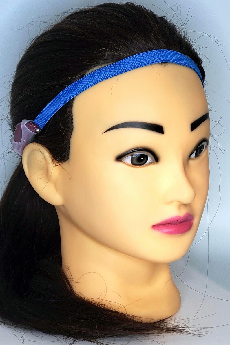 May include: A blue headband with a purple and silver hearing aid attached to the left side.